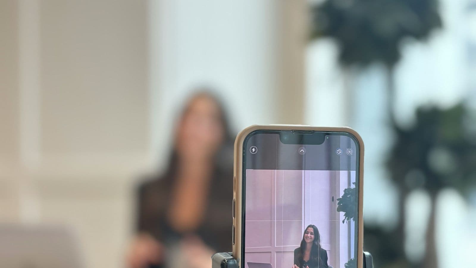 A woman recording herself with a phone on a tripod