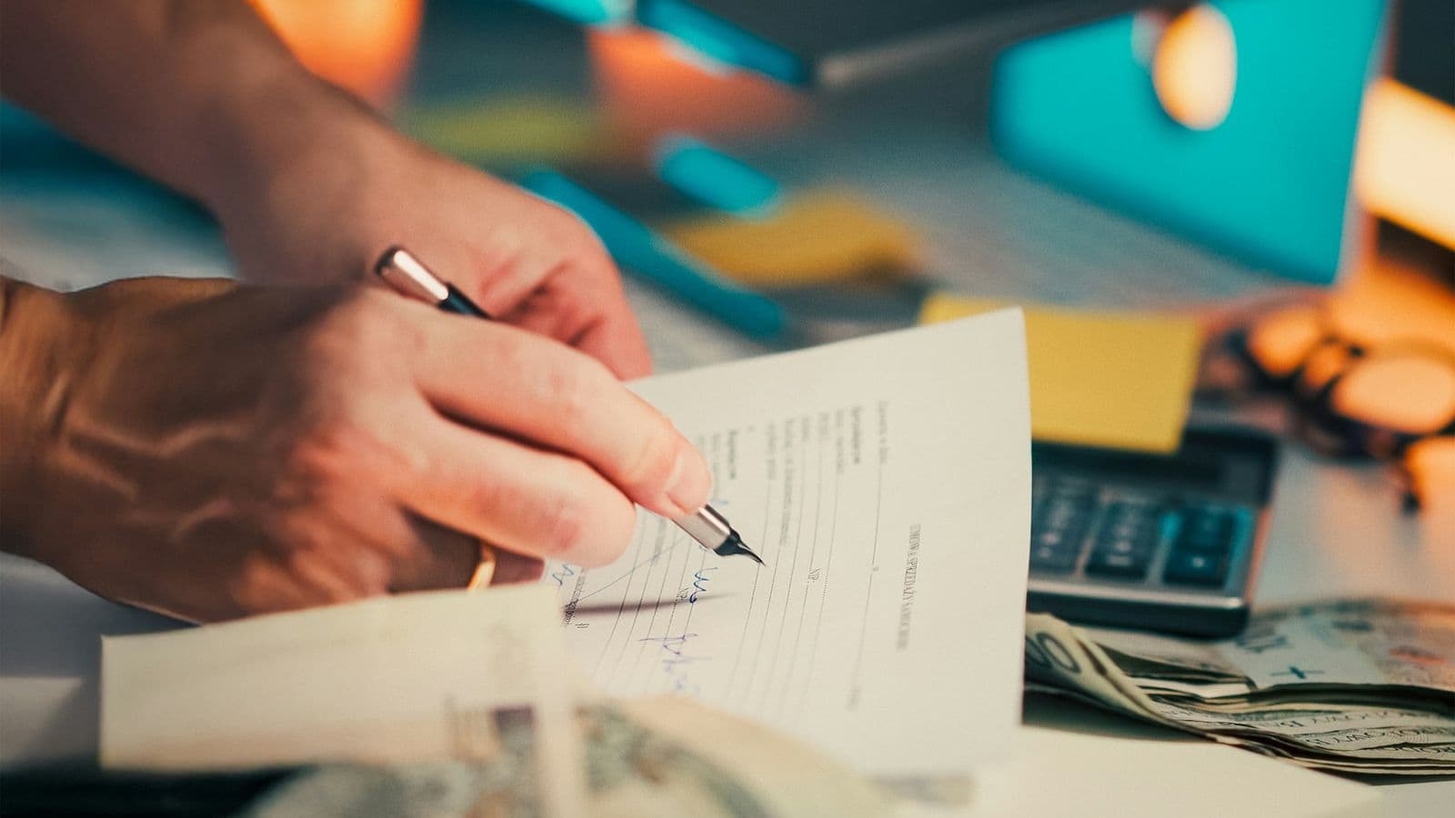Someone signing a document at a desk