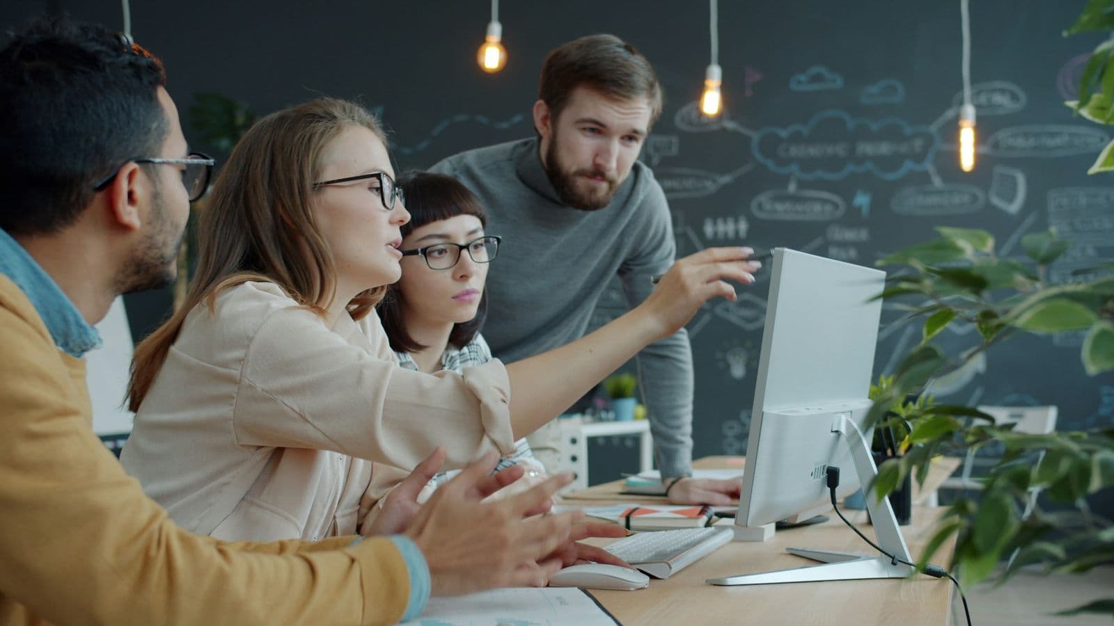A team of colleagues watching a screen together in an office