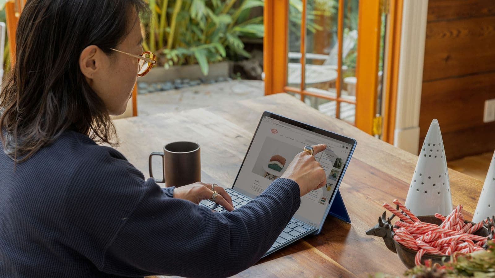 Someone browsing a website on a laptop at a kitchen table